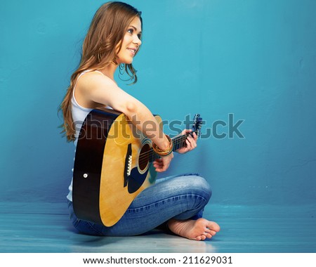 girl guitar play and sings . young model sitting on a floor. teenager style portrait.