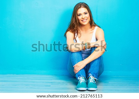portrait of teenager style female smiling model sitting on floor . pretty woman full body portrait