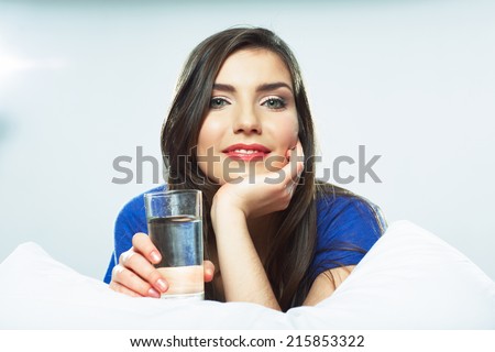Smiling female model portrait with water glass. Beautiful girl. Young woman drink water.