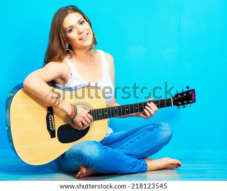 teenager girl guitar play . long haired girl sitting on a floor with crossed legs
