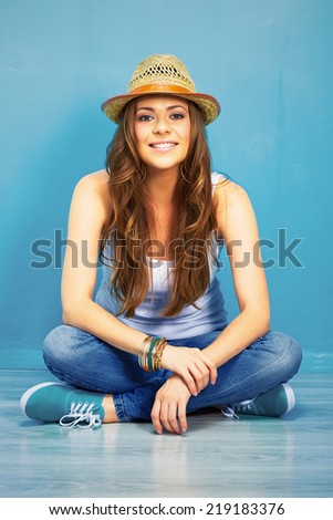 happy woman full body portrait . girl sitting on a floor in teenager style .  crossed leg