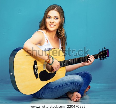 girl guitar play and sings . young model sitting on a floor. teenager style portrait.