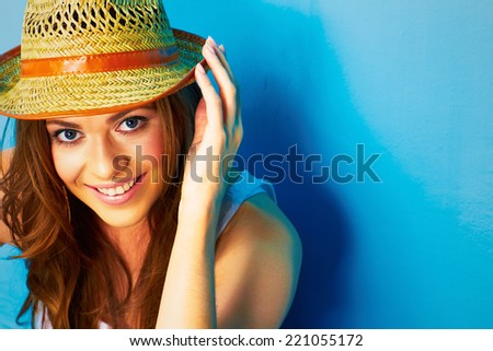 fashion portrait of young woman hand touching her straw hat . close up face .