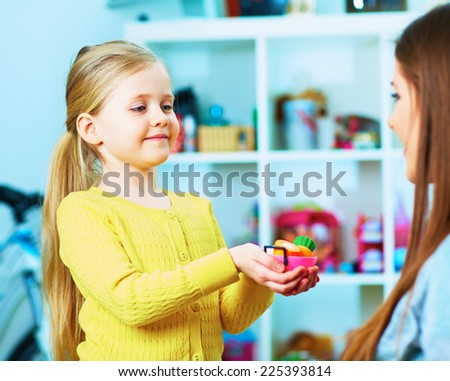 girl play with mother at home with toy food. home portrait in child room.