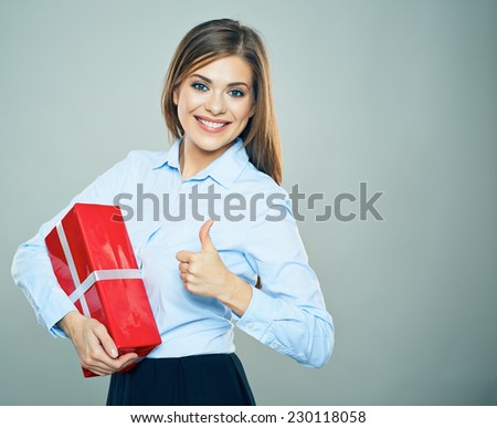 Happy woman show thumb up, hold red gift box. Business woman portrait isolated. Studio.