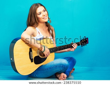 teenager girl guitar play . long haired girl sitting on a floor with crossed legs