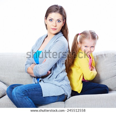 Woman with girl seating on sofa back to back. Relationship portrait.