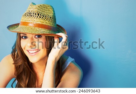 beautiful woman with straw hat smiling and happy . blue background .