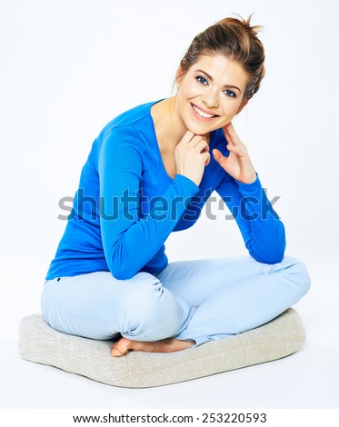 Young smiling woman sitting pose portrait. Yoga lotus pose of beautiful girl. Casual home style.
