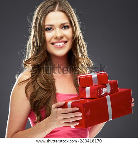 Smiling woman holding gift box. Studio portrait. Young female model.