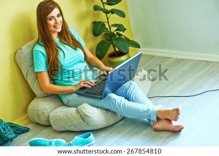 Young woman working with laptop at home. Smiling woman.