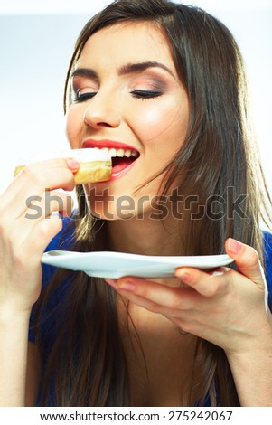 Woman bite donut. Close up portrait of young woman holding plate with donut.