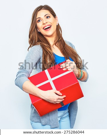 Happy Woman hold gift box. Big smile with teeth. Beautiful female model in studio. White wall background. Red gift box.