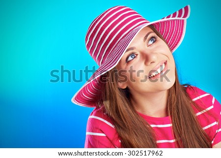 Young smiling woman looking up against blue background. isolated studio portrait.
