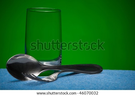 Glass and kitchen devices on a green background