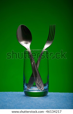 Glass and kitchen devices on a green background