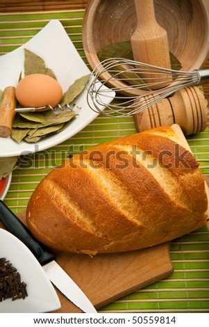 Various kitchen utensils are on the bamboo cloth with bread