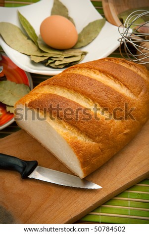 Various kitchen utensils are on the bamboo cloth with bread