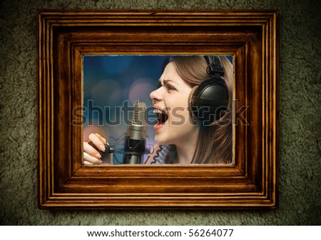 Wooden empty old frame on dirty  wall with portrait of singing woman inside