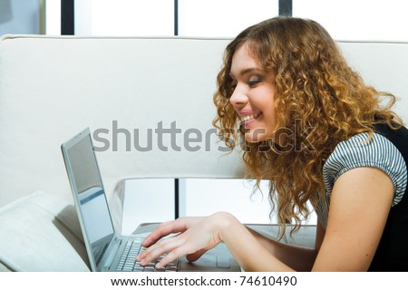 attractive woman happy and smiling in front of laptop display