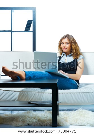 Young woman relaxing with  laptop on a couch. Indoor female portrait
