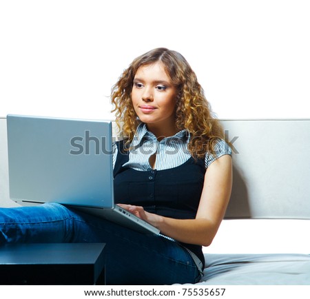 Young woman sitting with laptop on a couch. Indoor female portrait