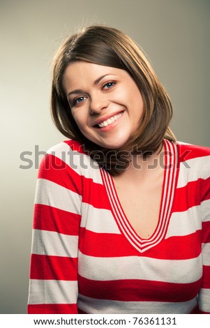 Portrait of young happy woman , big natural smile, beautiful model posing in studio over gray background . Isolated on gray. Light make-up without strong retouching natural skin.