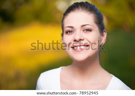 Young Woman on summer tree background. Outdoor portrait with big smile.