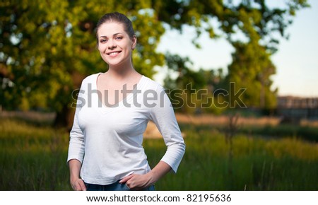 Woman portrait on green tree background. Outdoor portrait with big smile. Horizontal
