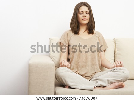 woman in yoga pose on sofa at home. relaxing portrait of beautiful girl