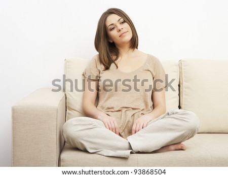 Portrait of smiling woman sitting on sofa. Casual style indoor shoot.