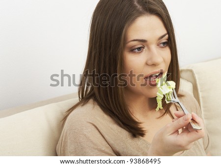woman eating vegetables and watches TV