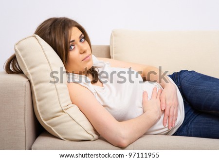 woman stomach pain.  female indoor portrait