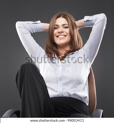 Young business woman [ student ] sits in office chair isolated on gray