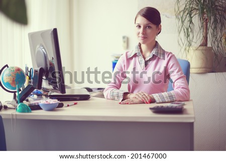 Portrait of young caucasian business woman in pink vest at her office