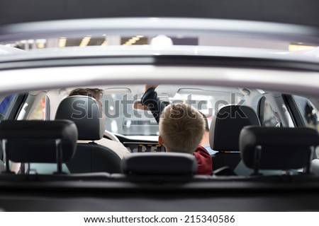 Boy touching the overhead panel of new modern car