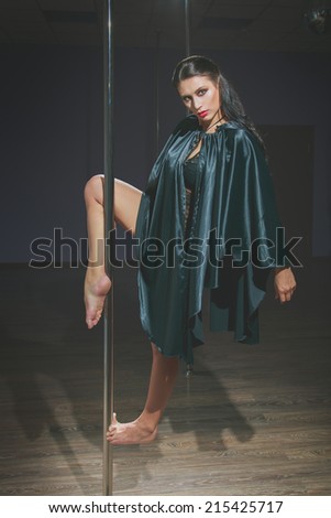 Attractive young caucasian woman dancing near the pole.