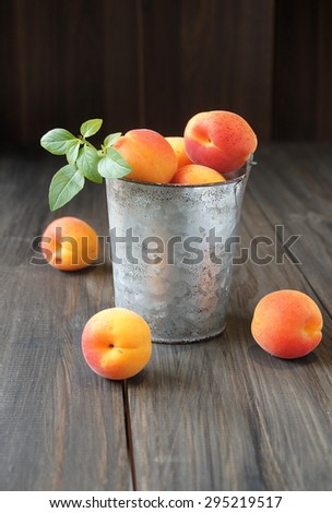 Juicy fresh peaches in a bucket on wooden table