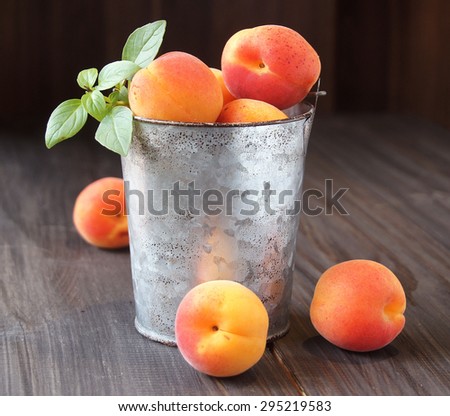 Juicy fresh peaches in a bucket on wooden table