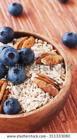 oat meal with walnuts and blueberries in a wooden bowl selective focus