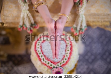 hand of a bride receiving holy water from elders in thai culture wedding ceremony