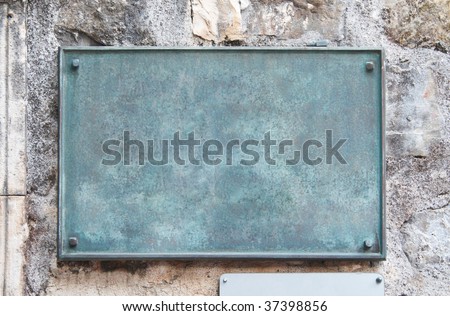 Blank copper signboard close-up over stone wall