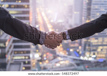 Business Collaboration, Businessman shake hands with blur background night city town.