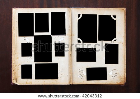 Vintage photo album with blanked photos on old wooden texture