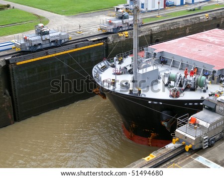 Ship in the panama channel lock centered by two locomotives