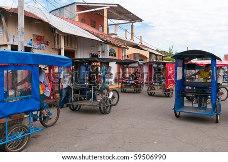 PUERTO CORINTO, NICARAGUA-OCT 7:Parking of the rickshaw taxi with unidentified drivers October 7, 2009 in Puerto Corinto. In the Nicaraguan rickshaw taxi driver is behind the passengers.