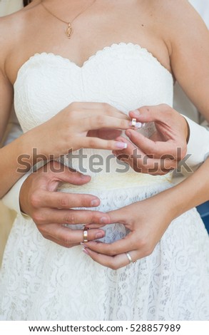 hand of the bride and groom wear a ring to each other