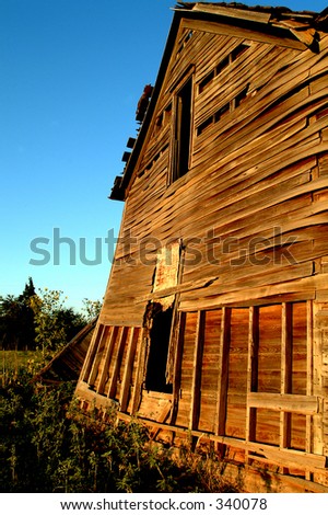 Old farm house that is leaning over about to fall down.