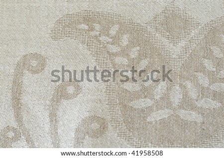 a detail of gray linen fabric with woven  ornaments