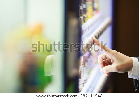 A business man standing in front of a vending machine